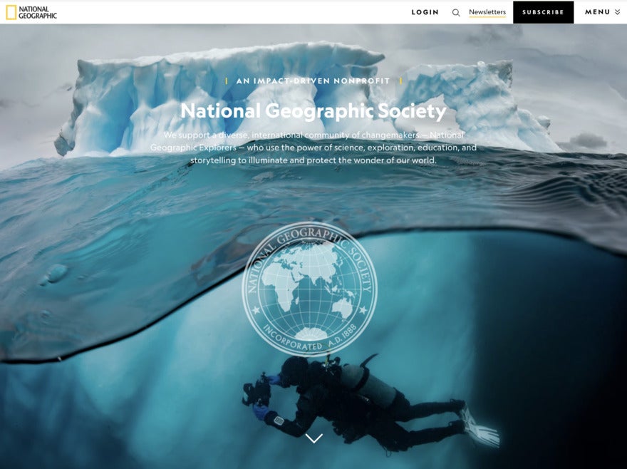 A screenshot of the NatGeo website featuring a photo of clear, green artic water - ice on top and a diver underneath.