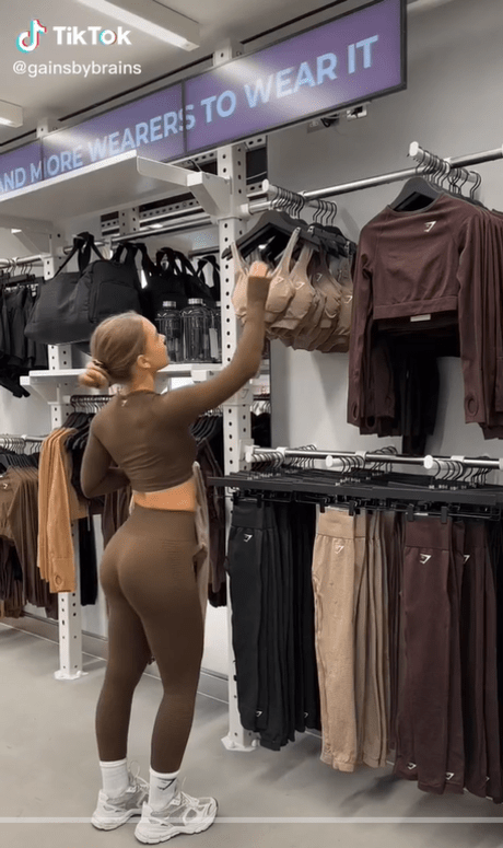 Girl in fitness gear browses sportswear in new Gymshark store